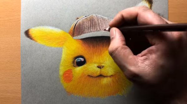 A hand holding a yellow colored pencil over a drawing of the children's character pikachu.