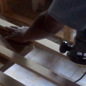 A electric sander is used to sand a few boards