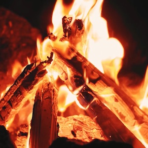 A photo shows the hot burning wood of a campfire as it burns to embers