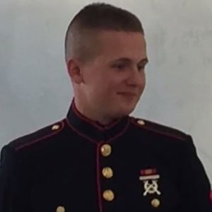 A man in marine dress blues smiles