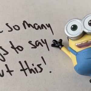 A minion cheers you on while standing in front of a piece of paper with writing on it