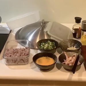 Various ingredients for this fried rice recipe sit on a counter, each prepared in its own bowl.