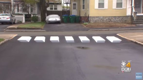 A crosswalk is drawn in a way that makes it look like it's floating above the paved street