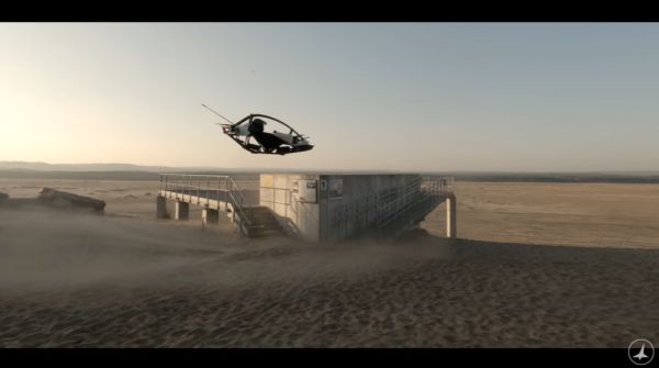 a small helicopter-like device above the sand in a desert