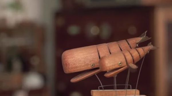 a shelf with several items that an inventor has created or adapted - a clock, a doll, and more