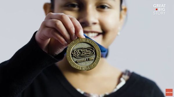 Girl showing medal that says 