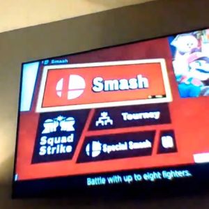 A TV screen shows the menu of a video game with the word 