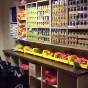 A pantry of food shows shelves full of canned food