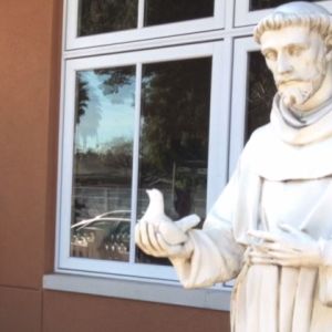 A statue of a missionary holding a dove